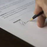 Podpis na dokumencie, który może oznaczać woltanic odstąpienie od umowy.