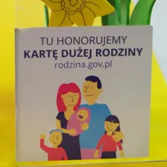 Grafika z napisem "Tu honorujemy Kartę Dużej Rodziny" i rysunkiem rodziny.