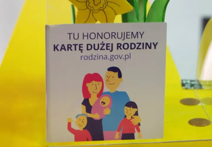 Grafika z napisem "Tu honorujemy Kartę Dużej Rodziny" i rysunkiem rodziny.
