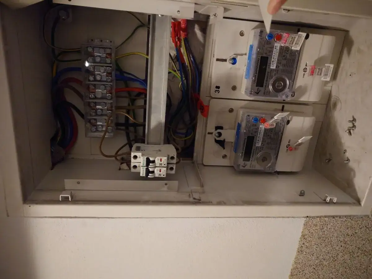 W skrzynce elektrycznej widoczne są dwa liczniki energii elektrycznej, bezpieczniki i przewody. Może to wskazywać na awarię licznika prądu.