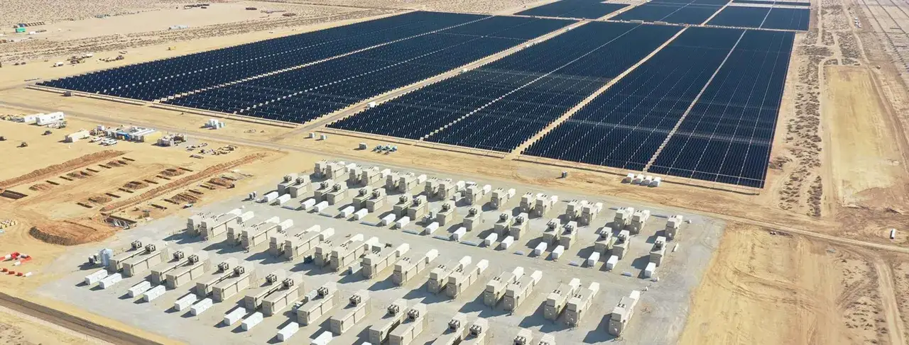 Ogromna farma fotowoltaiczna 1 MW w budowie. Widać rzędy paneli i kontenery z falownikami. Projekt farmy fotowoltaicznej 1 MW cena.
